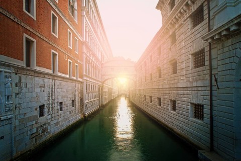 Ancient buildings and boats in the channel in Venice. Restaurant on foreground