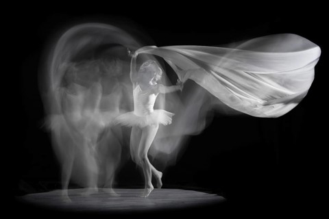 Ballerina in motion with flowing fabric, elegant and graceful in an artistic image, long exposure,