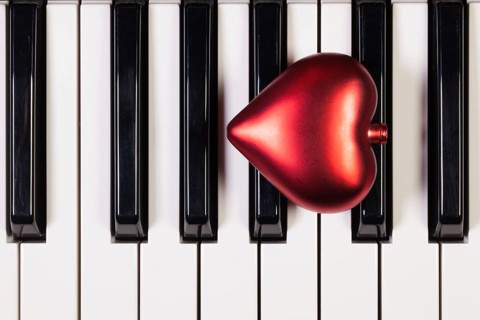 Detail of piano keyboard and red heart