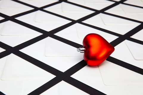 Composition with white envelopes and red heart on the table. The photo suitable for various