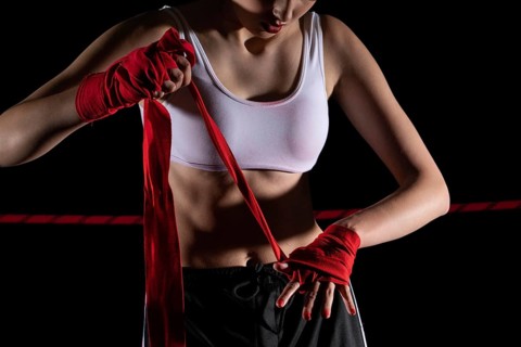 The athlete wraps her hands with a boxing bandage. Preparation for an important MMA fight. The