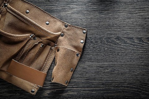 Leather tool belt on wooden board