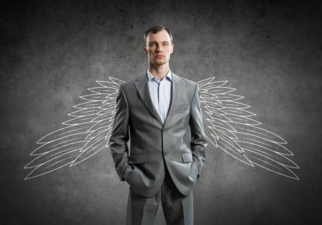 Young businessman with chalk drawn wings behind his back