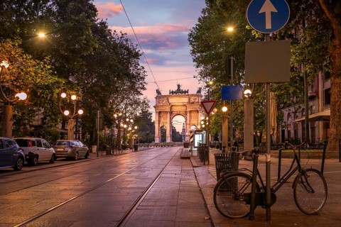 Road to the Arch of Peace and tram rails at sunrise in Milan, Italy