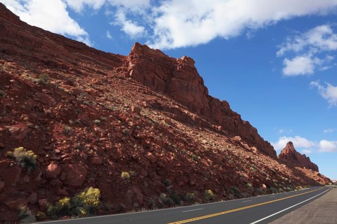 The magnificent American road passes between rocks of red sandstone