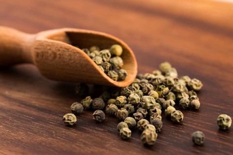 Green Peppercorns on wooden background