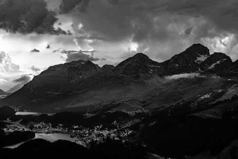 Beautiful Aerial View over Alpine Lakes and Swiss Alps and Cityscape in Sunset and Storm Clouds