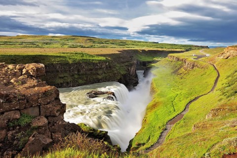 Grand Gullfoss in Iceland. Summer sunny day. Roaring water lit by the morning sun. The river banks