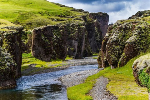 The beginning of the canyon Fyadrarglyufur, Iceland. The sheer cliffs covered with green moss