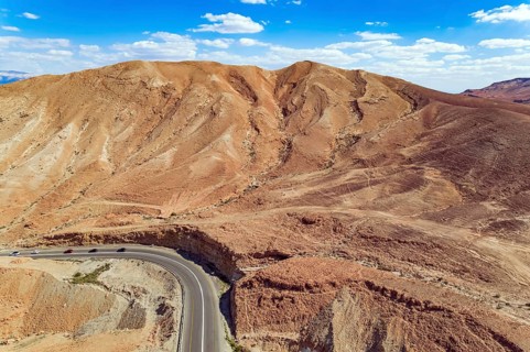 Judean desert on the shores of the Dead Sea. Dry waterless hills of yellow, beige and gray clay.