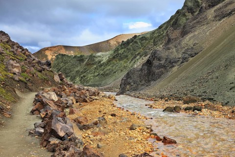 Steep mountain slopes, the path and the creek in the gorge. National Park Landmannalaugar in
