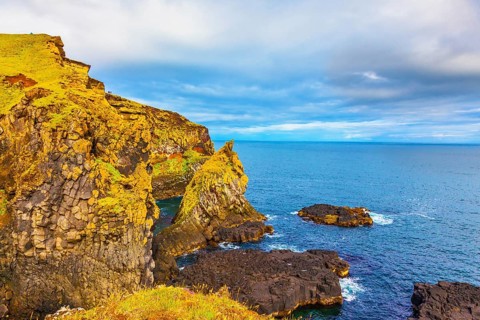 Scenic fjords on a cloudy summer day. Rocks covered with moss. Gorgeous Iceland. North sea coast