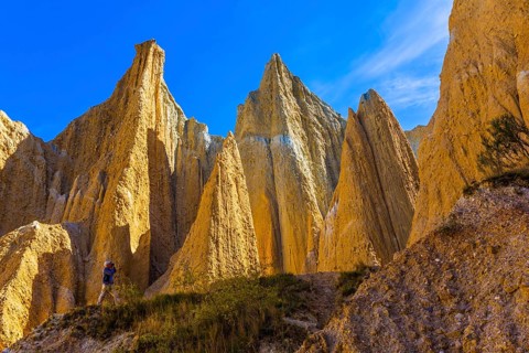 Elderly man takes pictures in the gorge. The Clay Cliffs are tall pinnacles separated by narrow