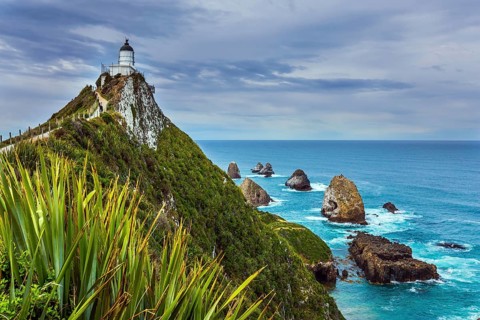 The picturesque coast of the Pacific Ocean. Nugget Point Lighthouse on the picturesque Cape Nugget.