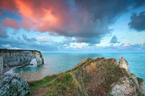 Dramatic purple sunrise over Atlantic ocean coast, Etretat, France