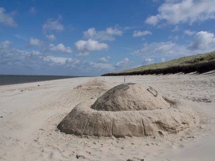 Beach landscape with a large sandcastle under a blue sky, spiekeroog, east frisia, north sea,