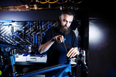 Theme sale and repair of bicycles. Young and stylish with a beard and long hair, a Caucasian man