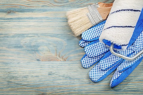 Paint roller brushes protective gloves on wood board construction concept