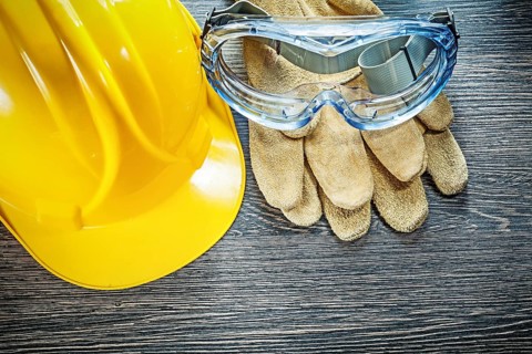 Safety goggles hard hat on wooden board