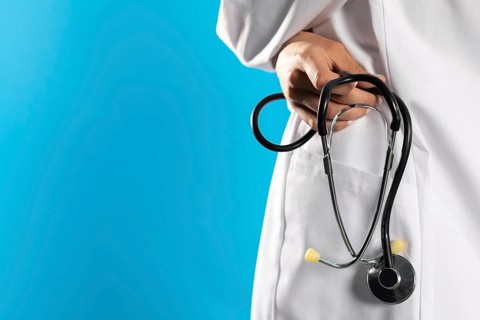 Close-up view of a hospital apron with a stethoscope in his hand