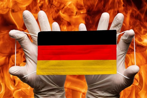 Doctor holding in white gloves protection medical face mask, respiratory bandage with Germany