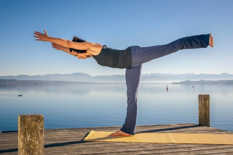 An image of a pretty woman doing yoga at the lake