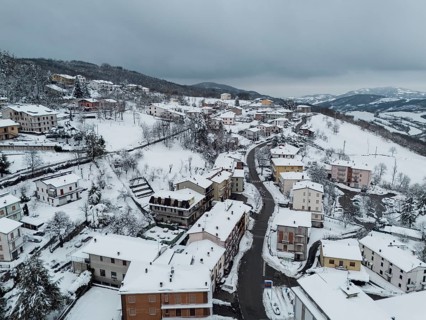 Aerial view of bore, a village in the province of parma covered by snow in december 2024,