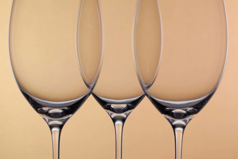 Three empty glasses of wine on a background