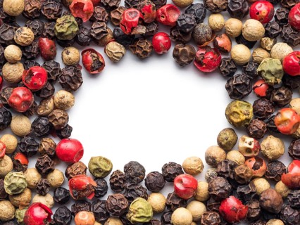 Mixed peppercorns background with white copy space in center. Food background with peppercorns.