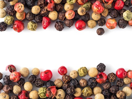 Mixed peppercorns background with white copy space in center. Food background with peppercorns.