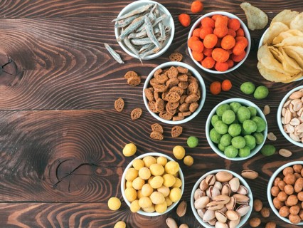 Assortment of different snack for beer, wine, party. Peanuts in coconut glaze, green vasabi, red