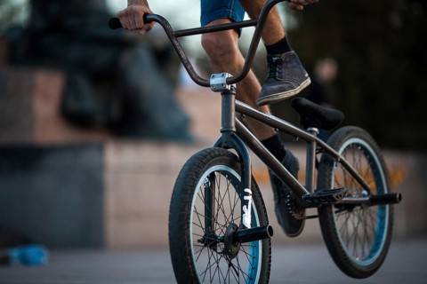 Young teenager bicyclist boy riding on beautiful orange bmx bicycle male hobby extreme sport male