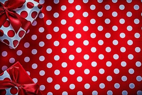 Decorated gifts on polka-dot red table cloth holidays concept