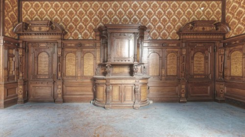 Detailed wooden cabinet in front of ornamental wall panelling in a historic room, Villa Woodstock,