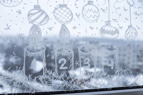Sustainable responsible holiday decor. Christmas advent candle painted on window glass indoor at