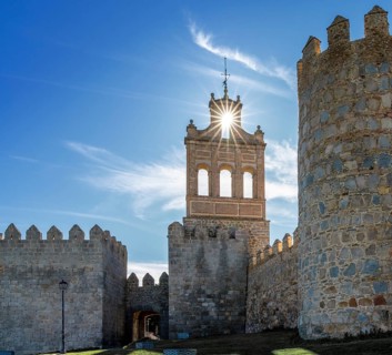 Avila, Spain, 8 April, 2024: view of the Avila city walls and the Puerta del Carmen with a sunstar