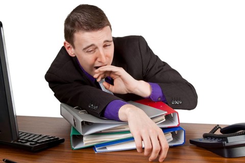 Young businessman yawning at his desk - Freisteller Young businessman yawning at his desk -