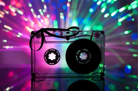 Cassette tape and multicolored pink blue lights on background