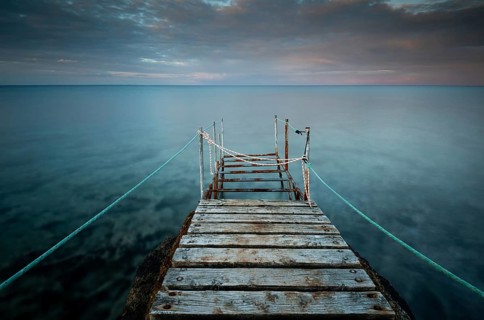 Long wooden pier in the sea at sunset. Protaras Cyprus