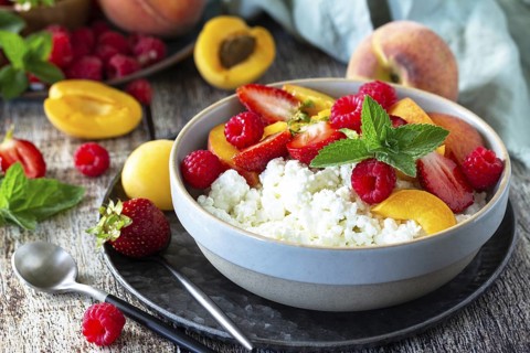 Rustic summer breakfast or dessert. Curd or cottage cheese served with fresh summer fruits and