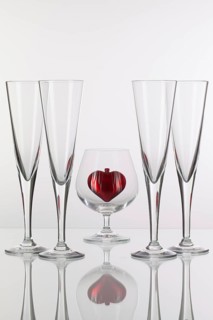 Different glasses and red heart on a glass plate