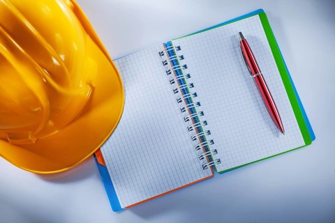 Hard hat notepad pen on white background