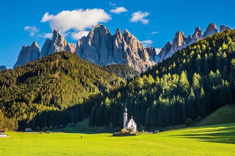 The famous symbol of the valley Val di Funes - church of Santa Maddalena. Rocky peaks and forested