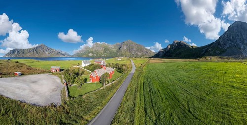 Aerial view of Flakstad church. In the background the peaks of the mountains Hustinden,