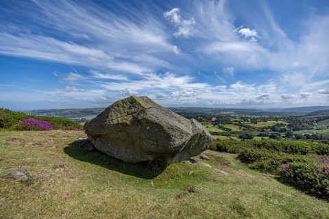 Large rock on a hill with sweeping views over a green landscape around Conwy and Conwy Castle on