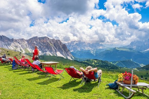 Hikers resting in deckchairs with a beautiful view in the Alps