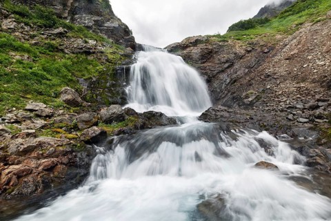 Scenery summer mountain landscape of Kamchatka Peninsula: beautiful view of cascade of flowing
