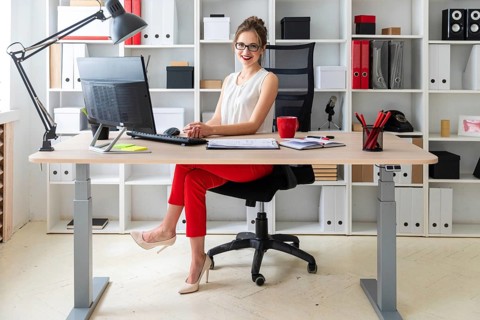 A young girl is sitting at the desk in the office