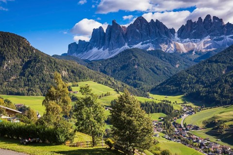 Dolomites, Val de Funes valley. Lovely autumn day. Picturesque mountains surround the green alpine