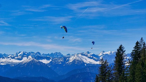 Paragliders on the Brauneck with a view of the Alps